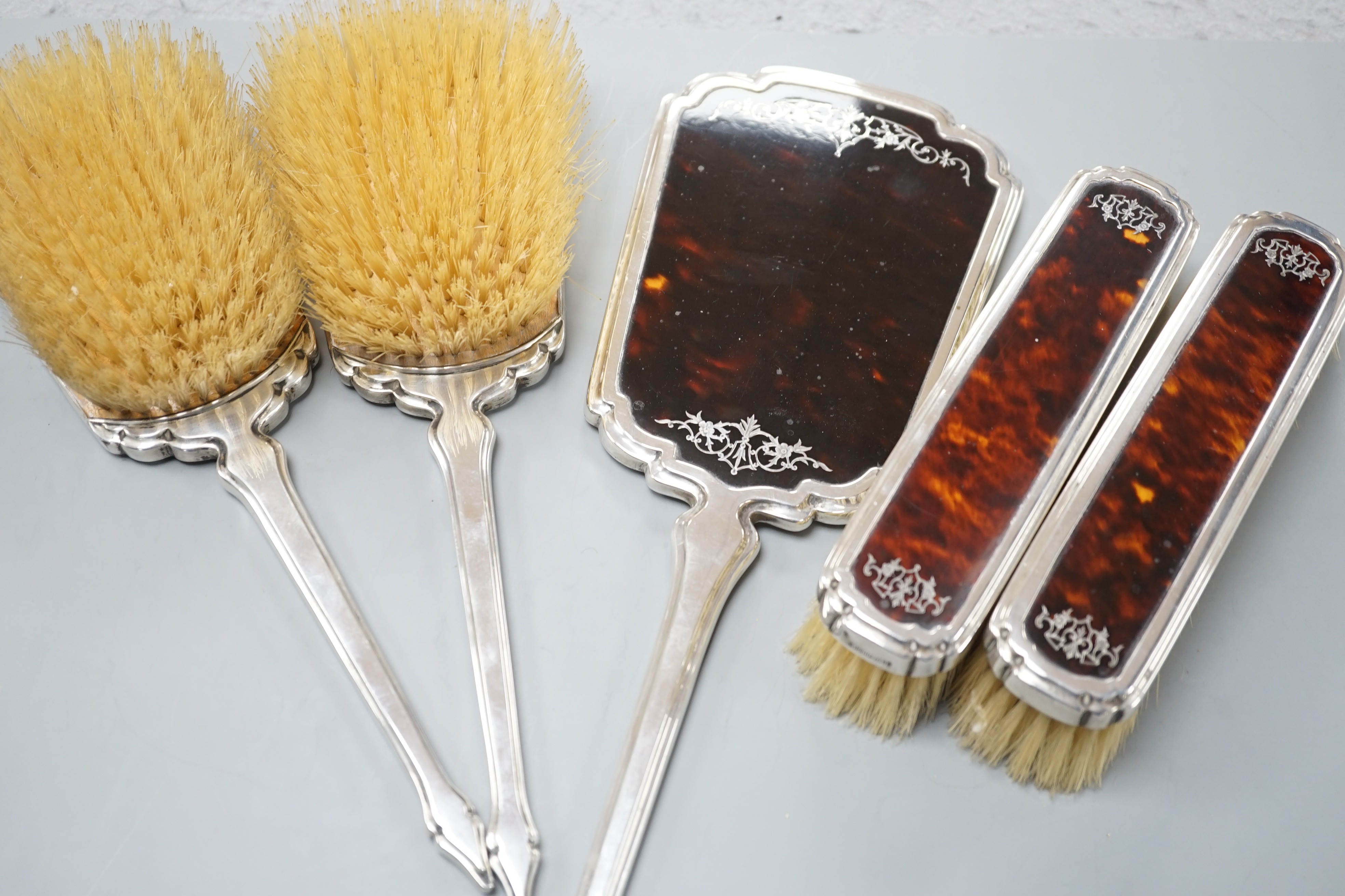 A George V silver and tortoiseshell mounted five piece mirror and brush set by Mappin & Webb, London, 1932/3.